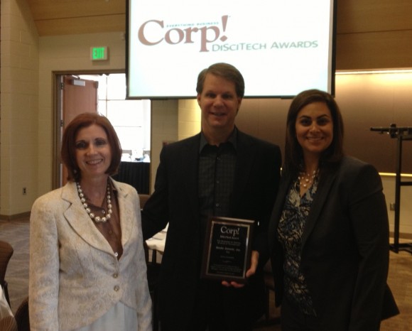 Brad Frederick, founder and CEO of Media Genesis, receives the Corp! Magazine DiSciTech award on April 18, 2013 from Corp! Magazine’s Executive Editor, Susan Voyles, and Publisher, Jennifer Kluge.